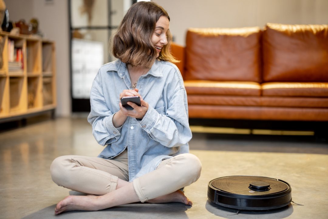 relaxed-woman-with-phone-and-robotic-vacuum-cleaner-1.jpg